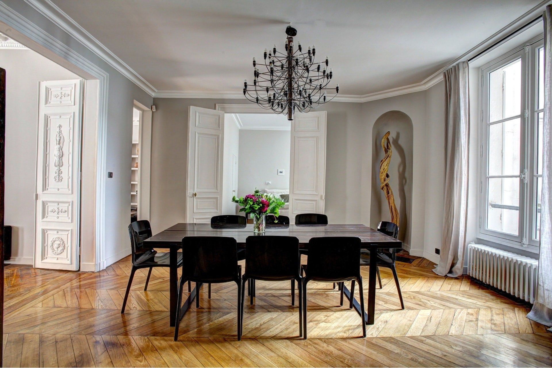Klassieke eetkamer met kroonluchter, parketvloer en monumentale deuren, gerenoveerd door Walraven Bouw