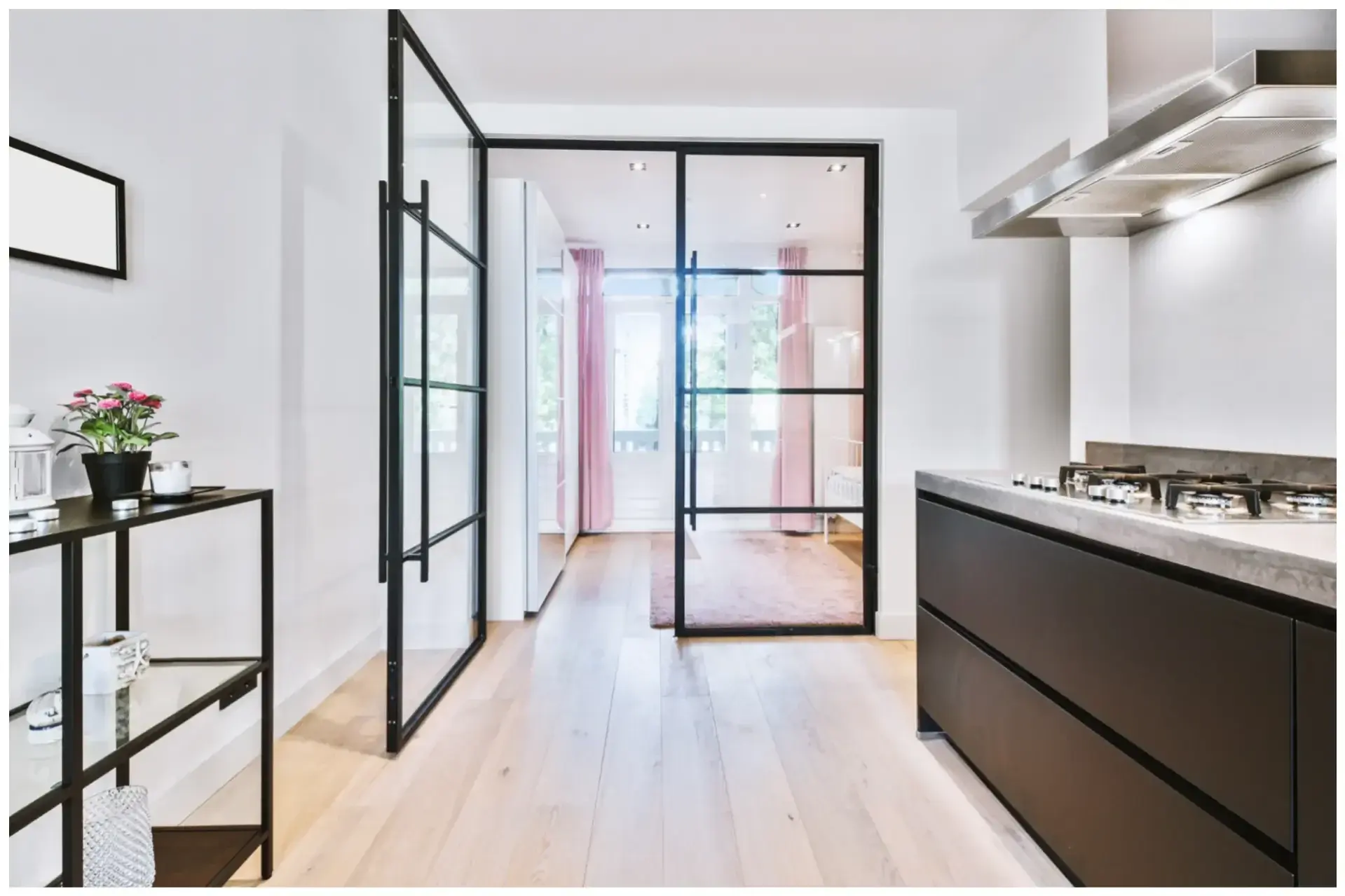 Zwarte keuken en gang met houten vloer en taatdeuren, gerealiseerd door Walraven Bouw in Huissen, met mogelijkheden voor stijlvolle interieurverbouwingen in Nijmegen, Arnhem en omgeving.