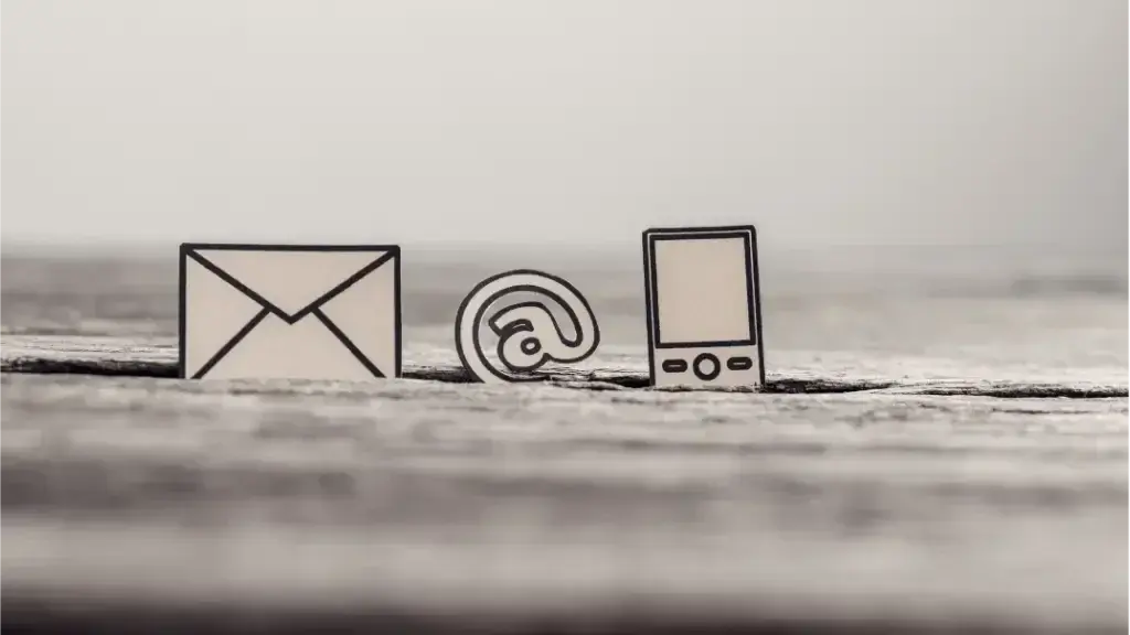 Getekende envelop, apenstaartje en telefoon op een houten ondergrond